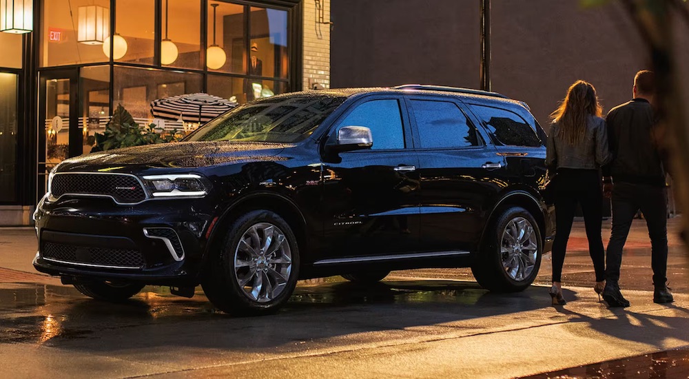 A black 2024 Dodge Durango Citadel parked by a city curb.