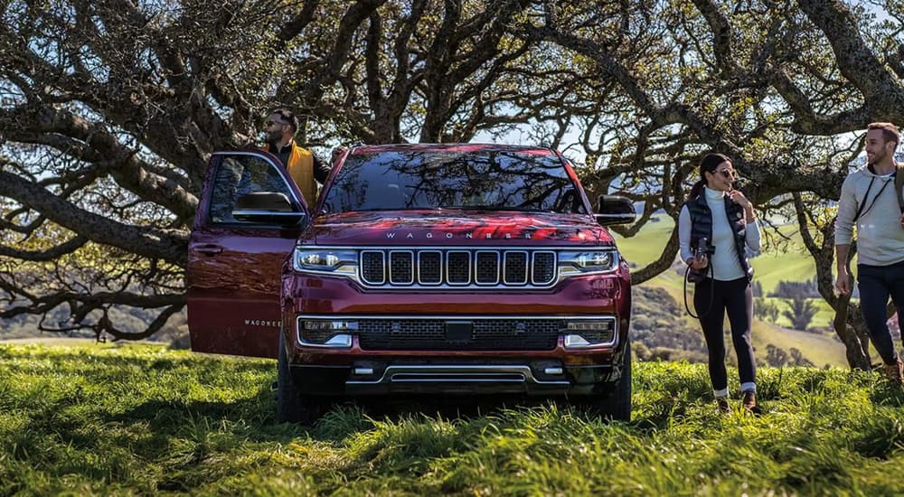 Front angle view of a red 2023 Jeep Wagoneer parked off-road.