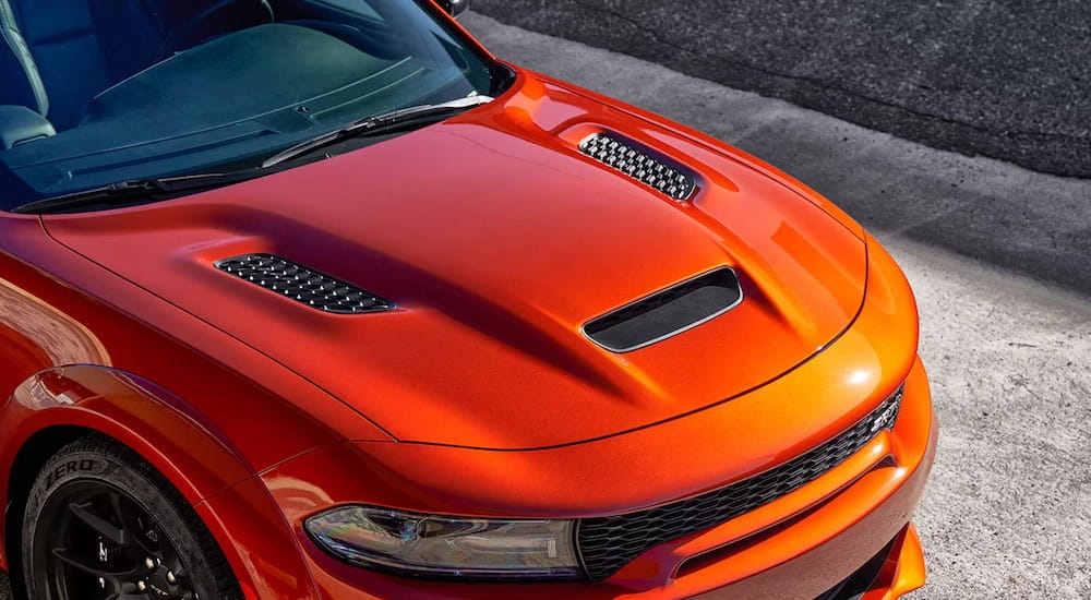 The hood of an orange 2023 Dodge Charger Hellcat Widebody is shown.