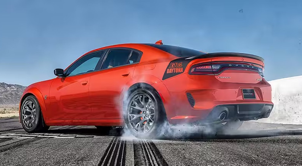 An orange 2023 Dodge Charger King Daytona is shown from the rear at an angle.