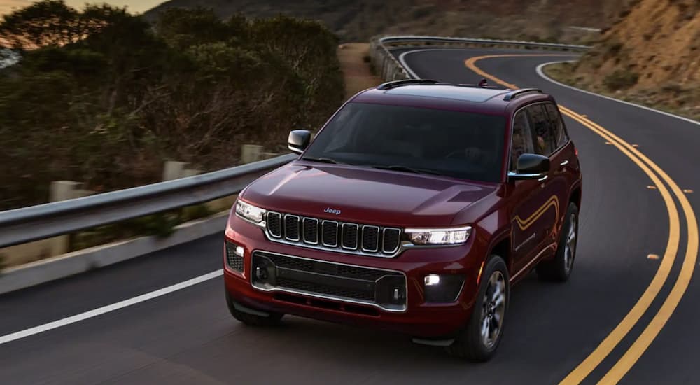 A red 2022 Jeep Grand Cherokee WL driving around a bend.