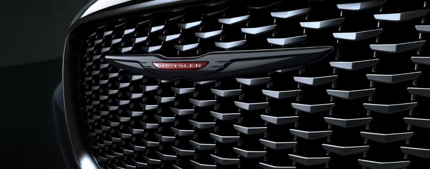 Close-up of the grille on a black 2023 Chrysler 300S at a Chrysler dealer near Clinton.