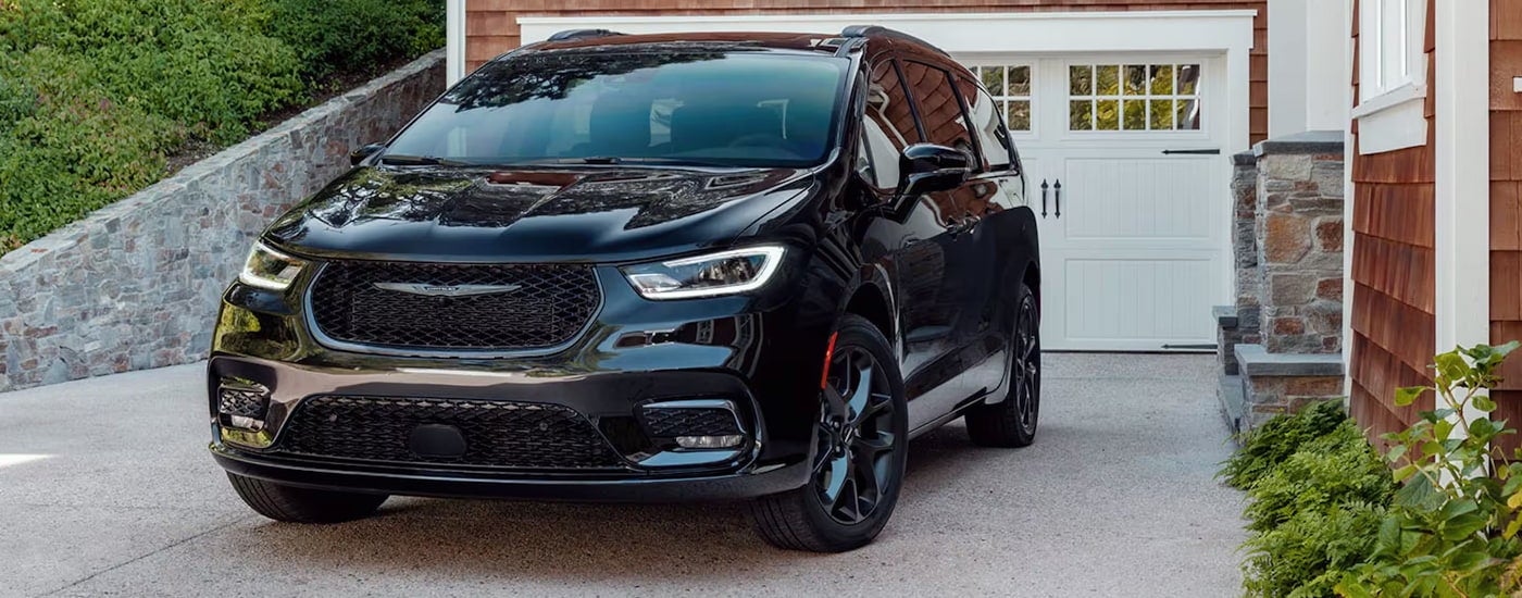 A black 2024 Chrysler Pacifica Limited parked in a driveway.