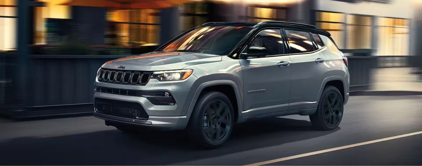 A silver 2025 Jeep Compass for sale is shown from the side.