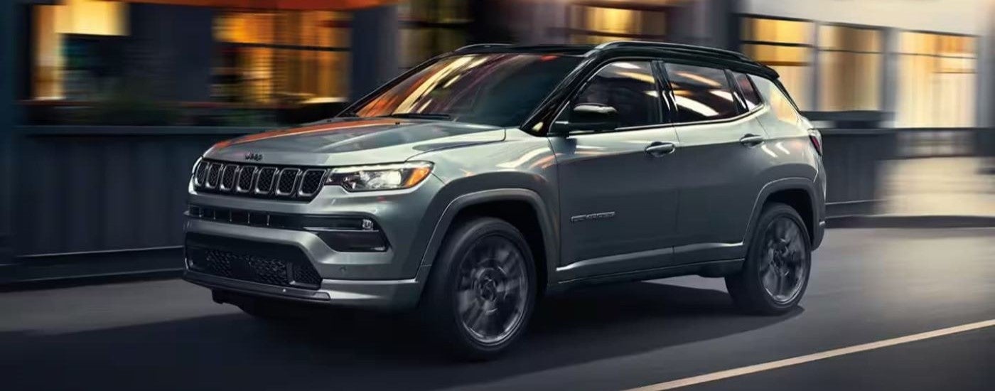Grey 2023 Jeep Compass driving through a city