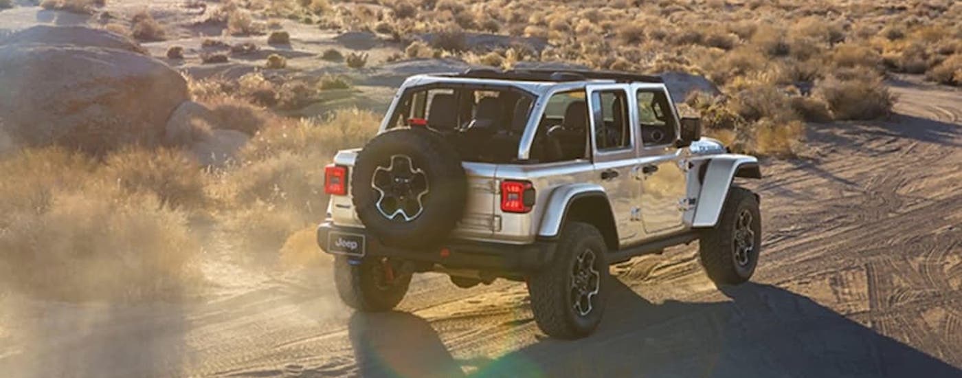 A silver 2023 Jeep Wrangler Rubicon 4xe is shown from the rear at an angle.