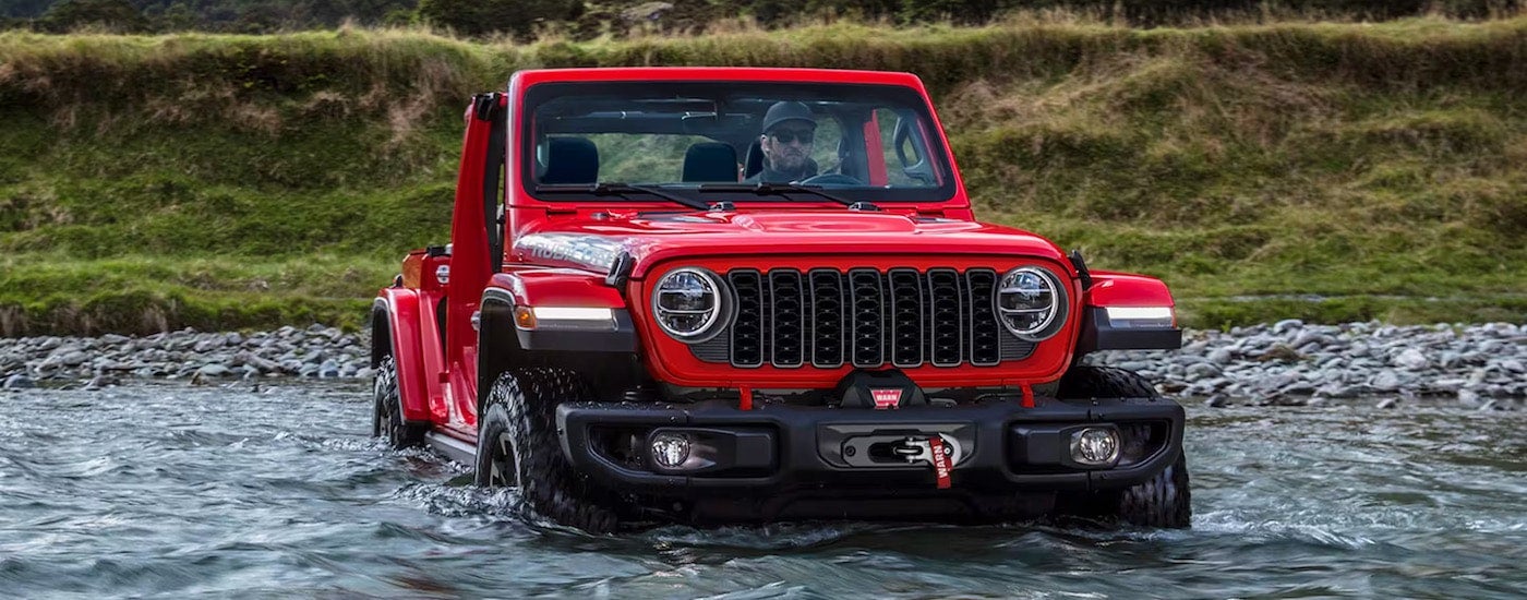 A red 2024 Jeep Wrangler for sale is shown from the front at an angle.