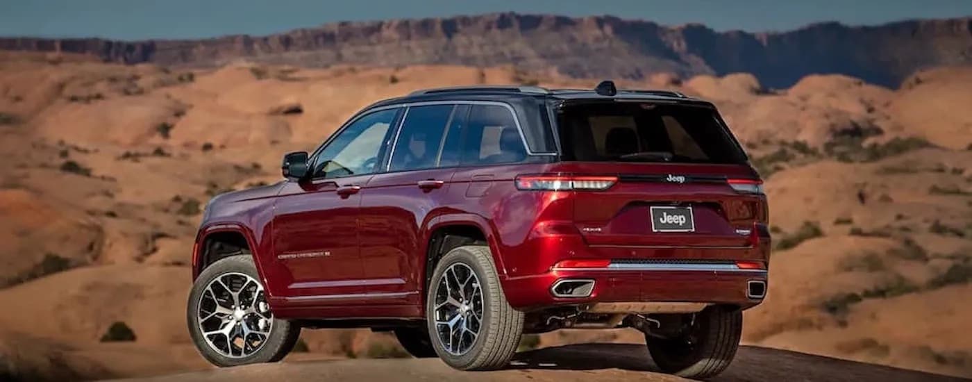 A red 2022 Jeep Grand Cherokee is shown from the rear at an angle.